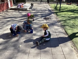 Päiväkodin lapset värittävät katuliiduilla.