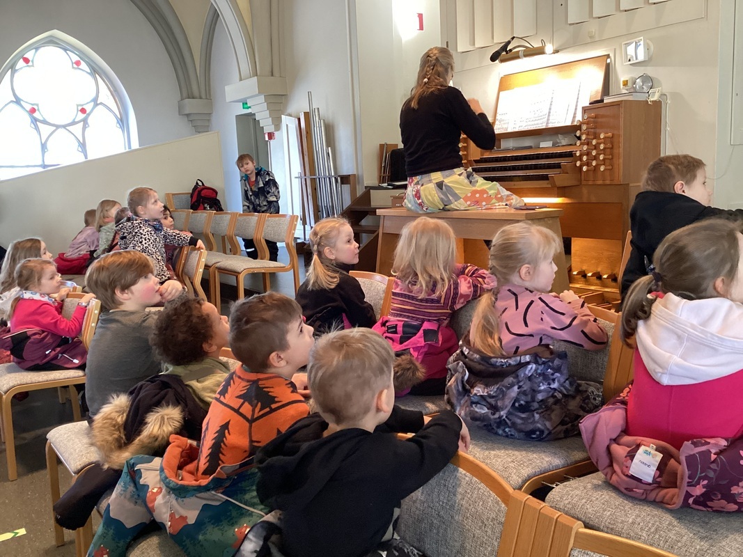 Lapset kuuntelevat urkusatua kirkossa