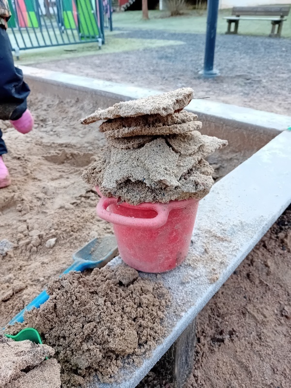 Jäätynyttä hiekkaa kerätty palasina hiekkaämpäriin.