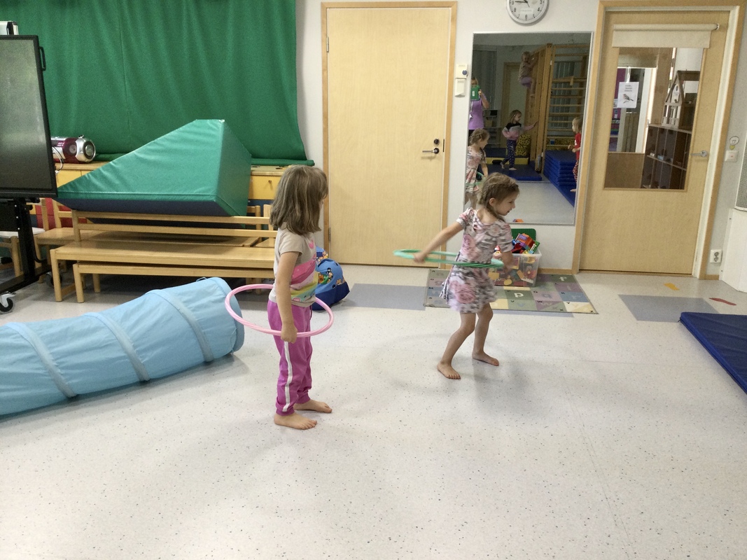 Lapsia leikkimässä hula-vanteilla.