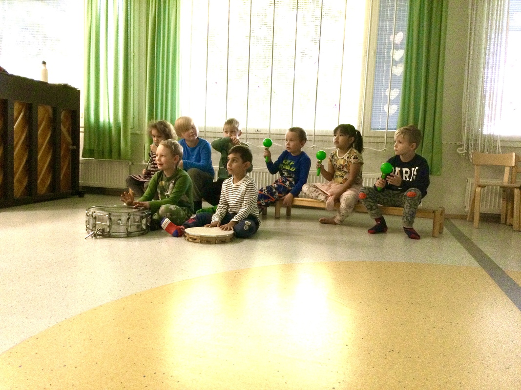 Lapset säestämässä laulua soittimilla.