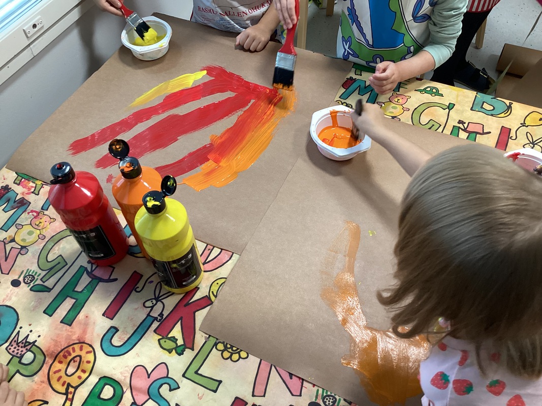 Lapset maalaavat tulenliekkejä.