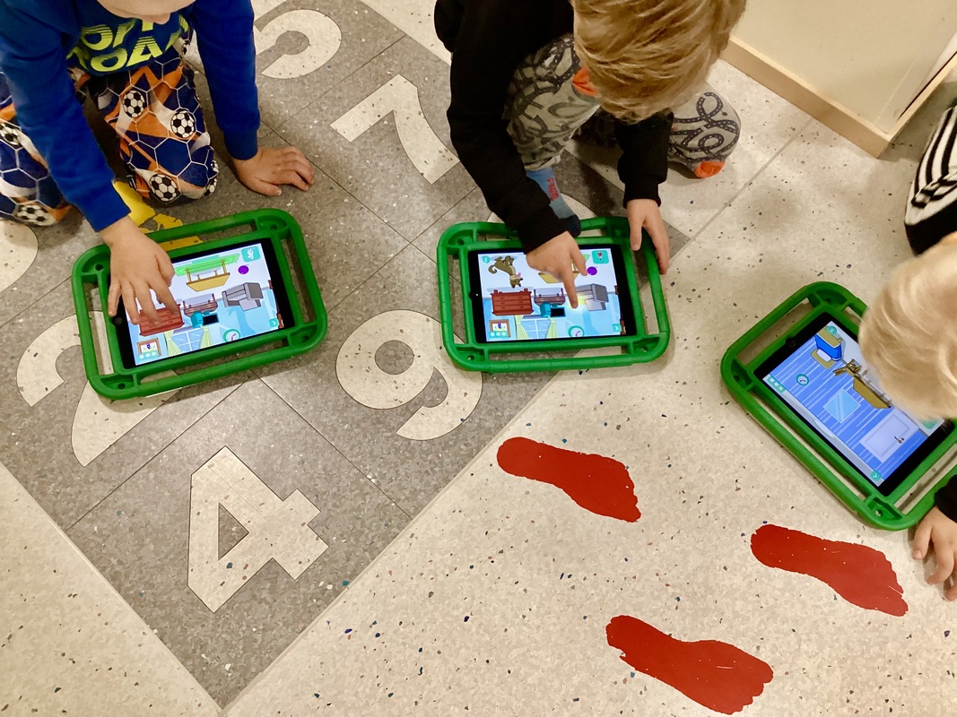 Lapset pelaavat Moomin language-peliä iPadilla.