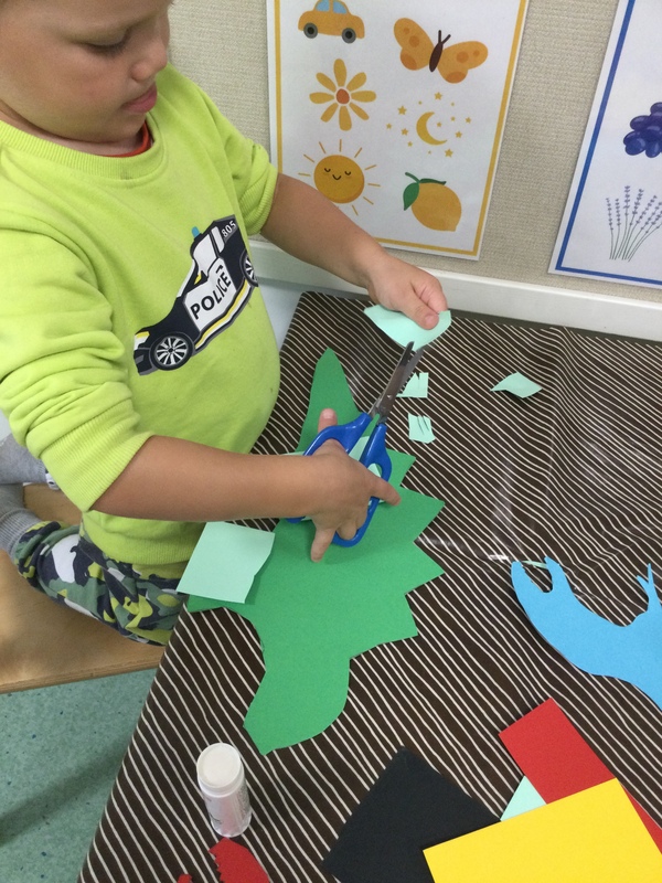 Kuvassa lapsi leikkaa saksilla kartonkia