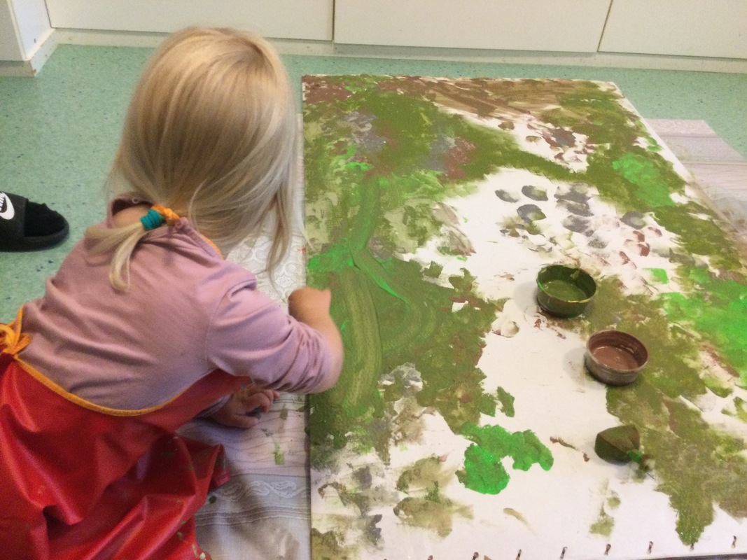 Yksi lapsi maalaa pahvia