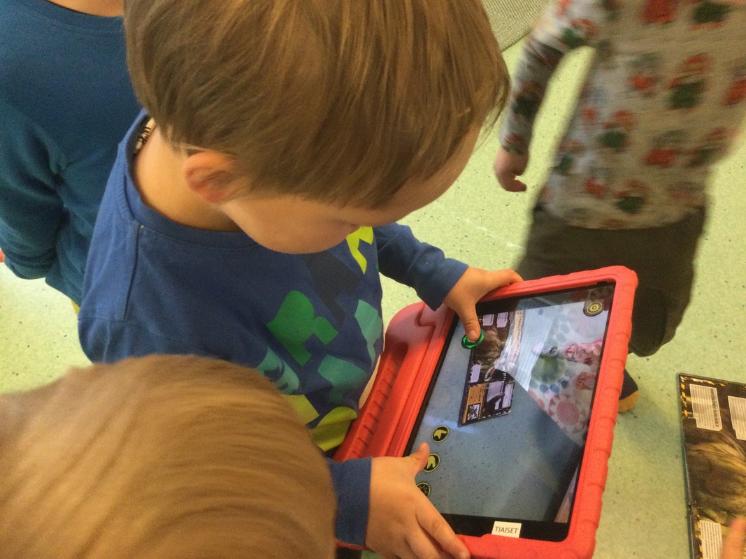 Kuvassa lapsella on punainen iPad kädessä
