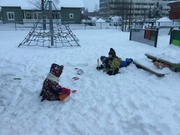 Lapset istuvat lumihangessa.