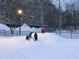 Lapset kiipeävät lumikasassa.