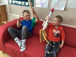 Pojat istuvat sohvalla askartelemiensa rakettien kanssa.