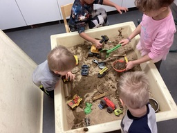 Lapset leikkivät hiekkalaatikolla.
