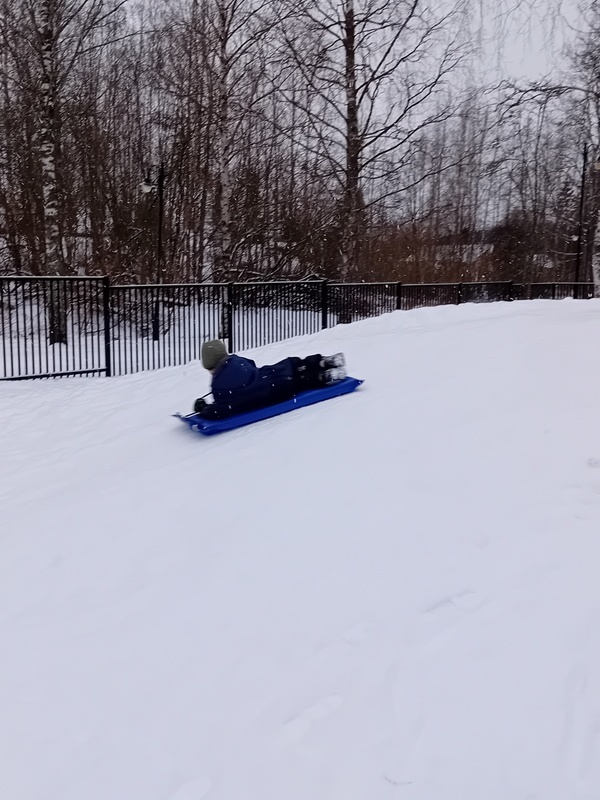 Lapsi laskemassa mäkeä isolla liukurilla.