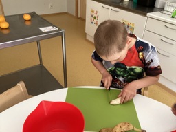 Lapsi pilkkoo hedelmiä.