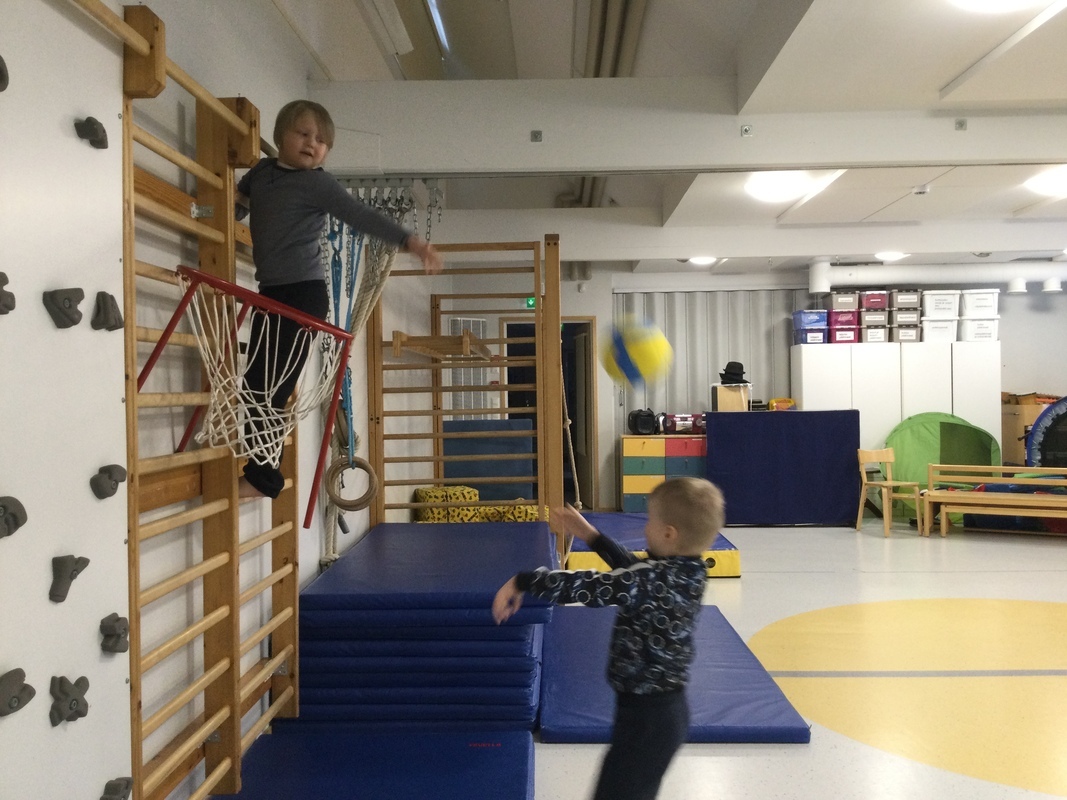 Lapset leikkivät salissa.