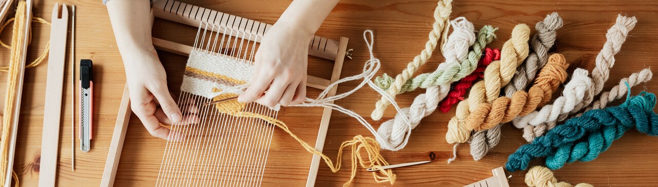 Pienet mattopuut, lankoja ja kädet askartelemassa