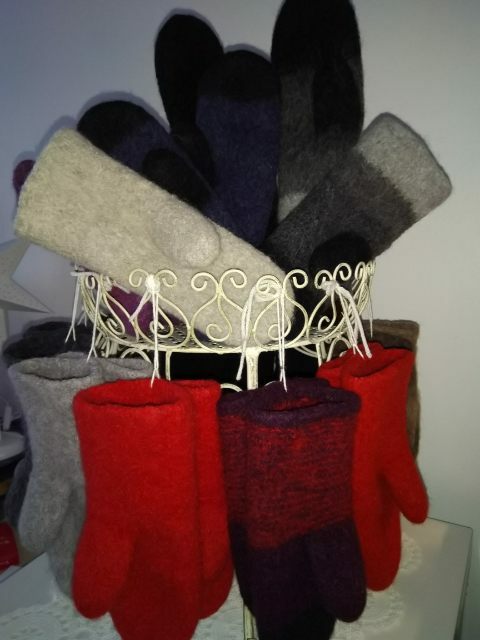 Monta paria erivärisiä huovutettuja villakintaita.