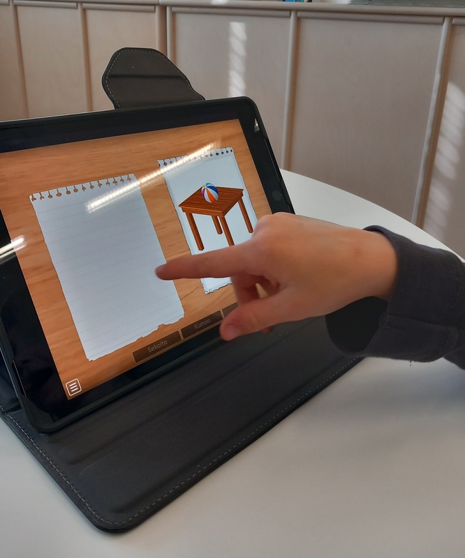 Lapsi tekee tabletilla sijaintikäsitetehtävää