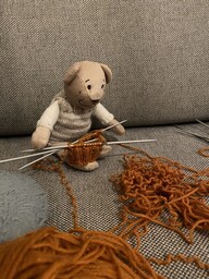 Reissu-Nalle auttamassa purkamaan kudottua villasukkaa