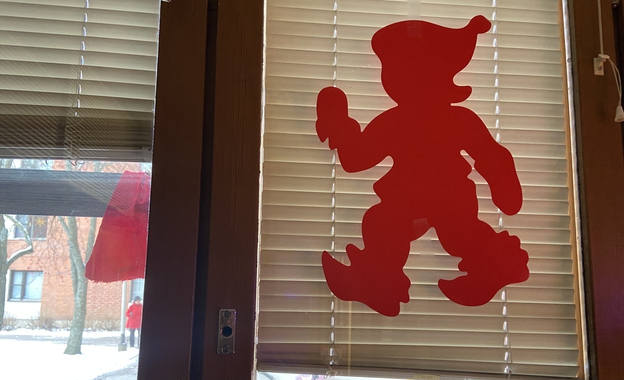 0637BCCC-39B5-4EC3-82EF-41D22A35AA82.jpeg Ikkunassa punainen tontun siluetti, ikkunan välissä pilkahtaa punainen tonttulakki.