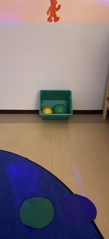 BC5B5337-E4A4-435F-86E8-69291298ACF6.jpeg Seinällä punainen tontun kuva, lattialla laatikossa kaksi palloa.