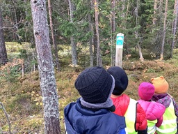 Lapset katsovat luonnonsuojelualueen merkkiä
