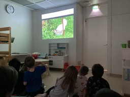 Lapset katsovat elokuvaa ja kuvassa mäkyy kana