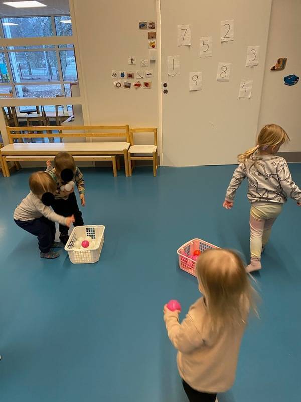 IMG_07171.jpg Lapset harjoittelevat jumppasalissa värienlajittelua punaisilla ja valkoisilla palloilla.