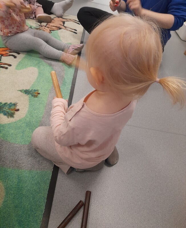 Kuvassa lapset soittavat kapuloilla.