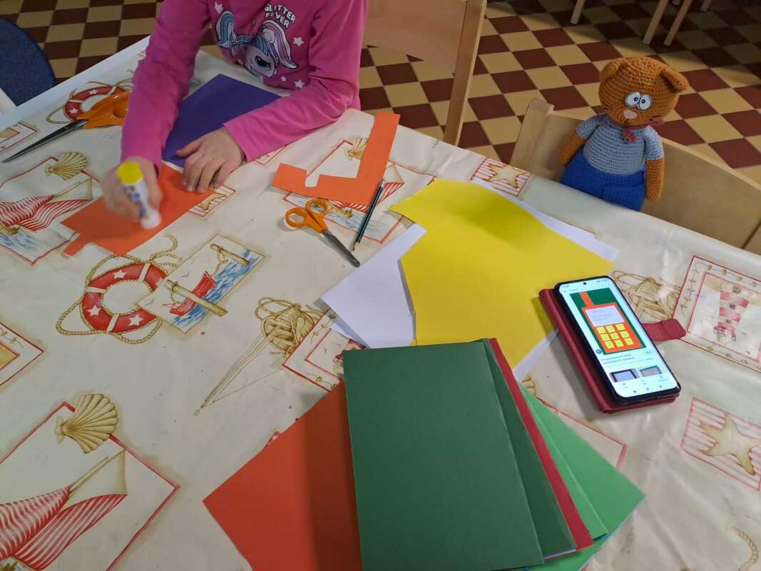 Sankarkikissa ja lapsi askartelemassa