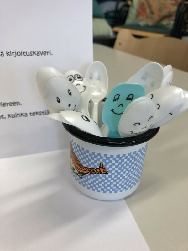 Kertakäyttölusikalle on piirretty kasvot. Lusikoita on purkissa useita.