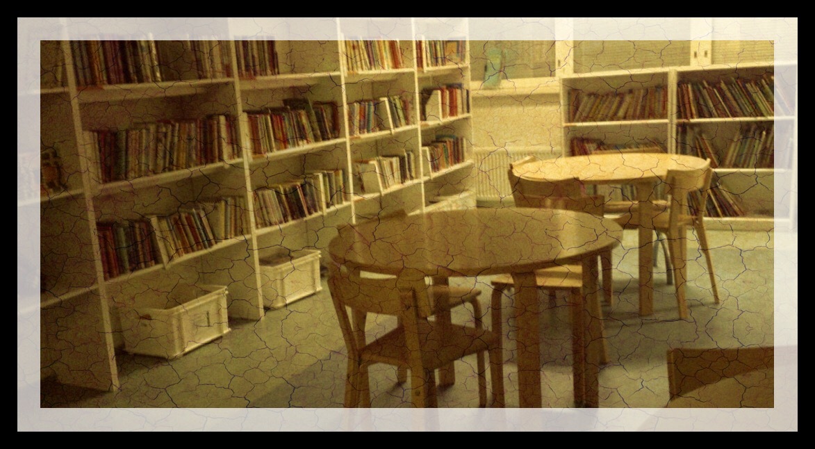 Kuva kirjastohuoneesta, jossa vasemmalla kirjahylly ja oikealla kaksi pyöreätä pöytää tuoleineen.