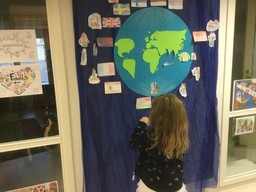 Lapsi katsoo maapalloa ja tutustuu lippuihin.