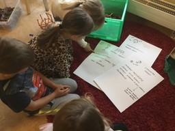Lapset tutkivat vaihtoehtoja lapsen oikeuksien viikon toiminnaksi päiväkodissa. Vaihtoehdot on piirretty ja kirjoitettu papereille.