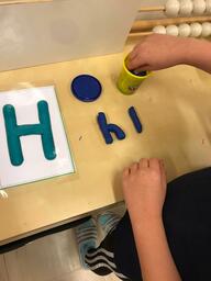 Pulpetti, jolla on Hh -kirjaimen kuva ja oppilas on muovaillut muovailuvahasta mallin mukaan kirjaimia.