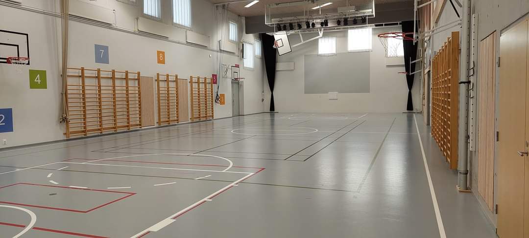 Iso jumppasali, jossa puolapuut, köydet ja viivat lattiassa.