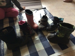 Lasten kenkiä rivissä maassa.