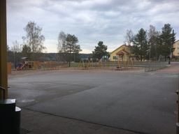 Koulunpiha, jossa keinuja, hiekkalaatikko, monitoimi kenttä, kiipeilyteline.