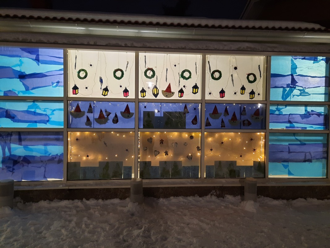 Ikkunoihin on kiinnitetty värillisiä papereita ja lasten askarteluita.