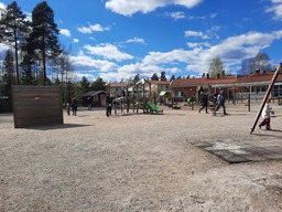 Yleiskuva päiväkodin pihalta, jossa liikkuu ihmisiä.