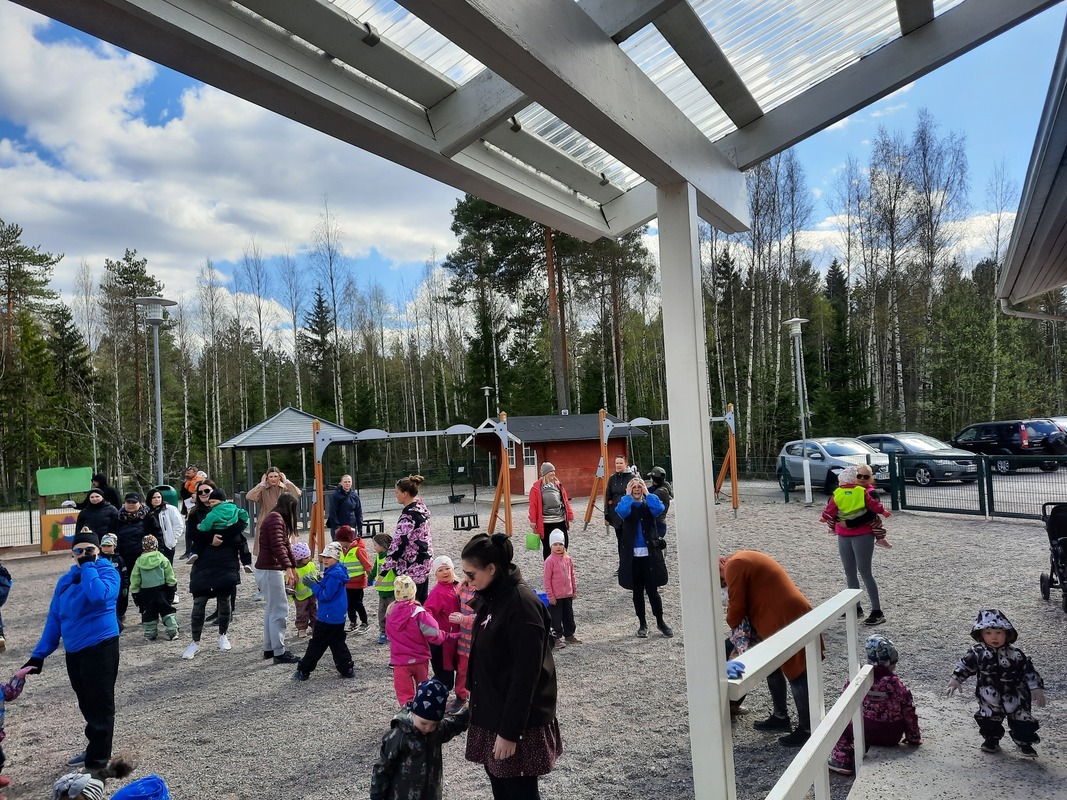 Ihmisiä liikkumassa päiväkodin pihalla.