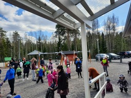 Ihmisiä liikkumassa päiväkodin pihalla.