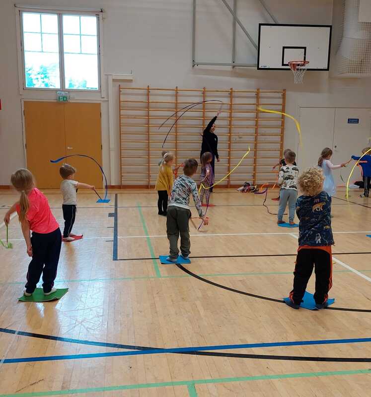 Lapset liikkuvat jumppasalissa.