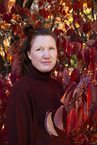 Kuvassa päätoiminen kuvataiteen opettaja Elina Julin punalehtisen puun vieressä.