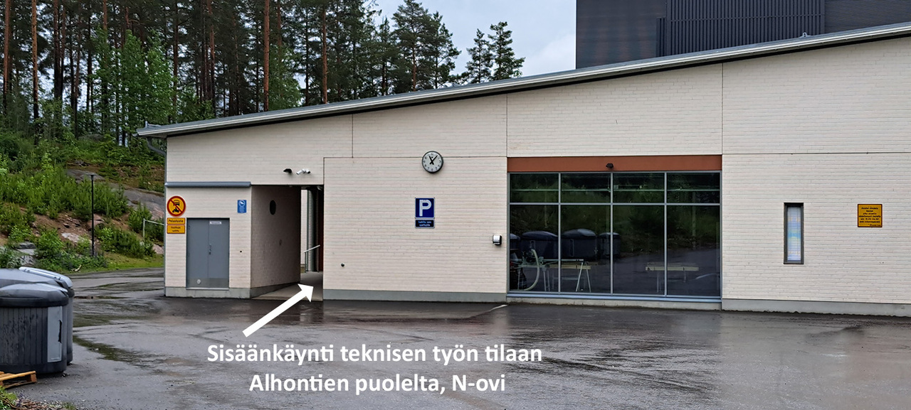 Kuvassa ohjeistetaan nuolella teknisen työn tilan sisäänkäynti Alhontien suunnalta.