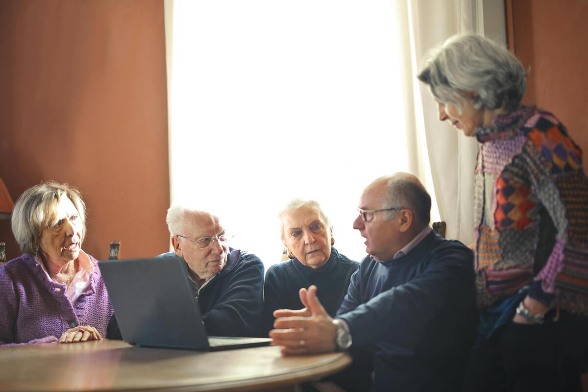 Ryhämä senioreita keskustelee tietokoneen äärellä