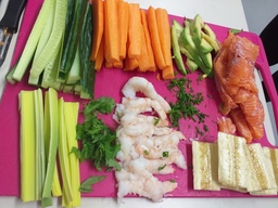 Kuvassa leikkuulaudalla pilkottuja kasviksia, kalaa ja äyriäisiä.