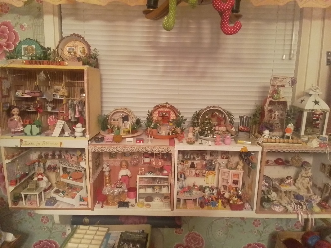 Kuvassa minimaailmoja huoneen seinustalla.