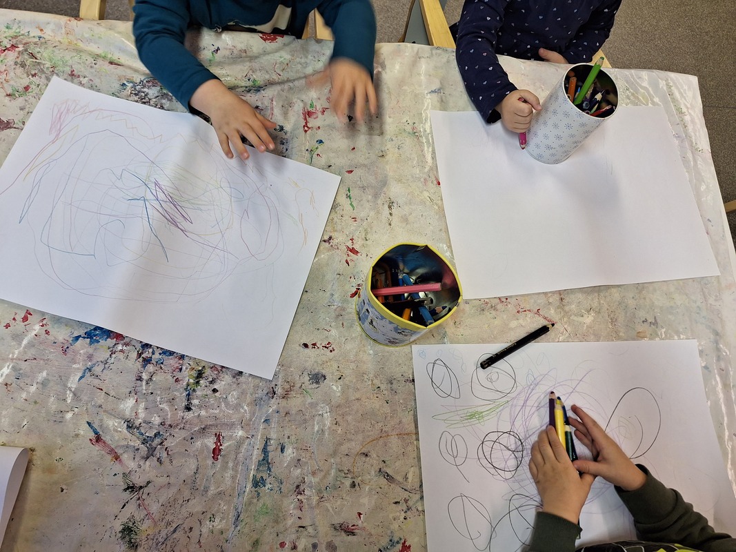 Bild av barn som tecknar på vitt papper.