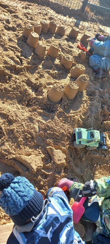 Barnen leker tillsammans i sandlådan